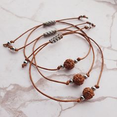 Handmade bracelet, crafted with care using a cotton brown cord, a sacred Rudraksha bead, and stainless steel beads. Embrace the powerful healing properties of Rudraksha, known for promoting tranquillity, clarity of mind, and positive energy. Elevate your spiritual journey and style with this unique and meaningful accessory, designed to bring harmony and balance to your life. 🚩 Bracelet is well-suited for both women and men, ensuring a comfortable fit for a wide range of wrist sizes, with a maxi Adjustable Brown Bracelet For Festivals, Adjustable Brown Bracelets For Festivals, Spiritual Brown Beaded Bracelets With Adjustable Cord, Adjustable Bohemian Bracelets For Puja, Adjustable Brown Jewelry For Puja, Spiritual Friendship Bracelets With Round Beads And Adjustable Cord, Spiritual Waxed Cord Bracelets With Round Beads, Spiritual Friendship Bracelets With Round Beads For Festivals, Adjustable Bohemian Beaded Bracelet For Puja