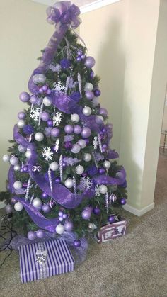 a purple christmas tree decorated with silver and white ornaments