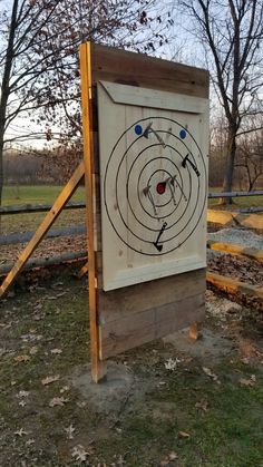 a wooden target board with arrows in the center