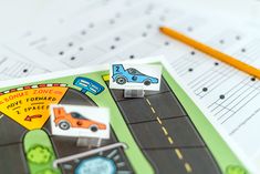 a close up of a piece of paper with cars on it next to a pencil