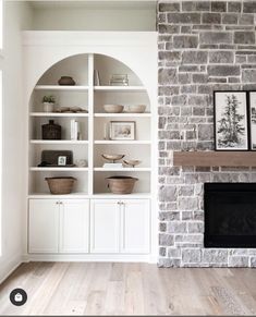 a living room filled with furniture and a fire place in front of a brick wall