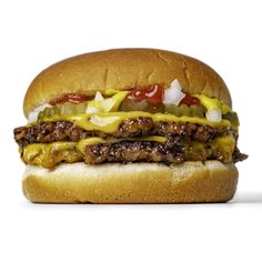 a cheeseburger with onions, ketchup and mustard on a white background