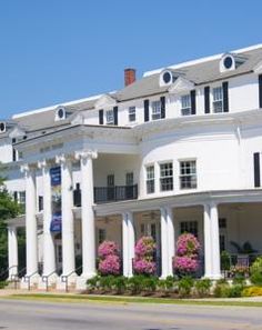 a large white building with columns and flowers on the front