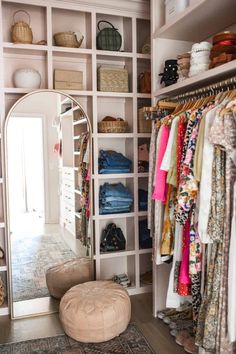 the closet is full of clothes and other items, including an ottoman or poufce