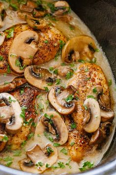 a pan filled with chicken, mushrooms and parsley sprinkled on top of it