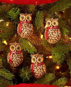 an owl ornament hanging from a christmas tree with red ribbon and pine cones