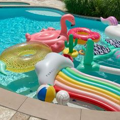 an inflatable pool with flamingos, water toys and beach balls on it