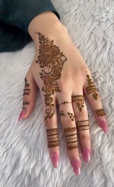 a woman's hand with henna tattoos on it