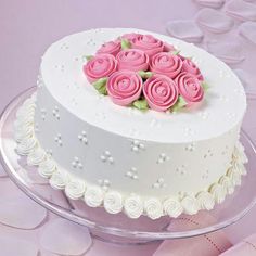 a white cake with pink roses on top