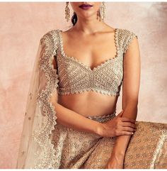 a woman in a bridal outfit posing for the camera with her hands on her hips