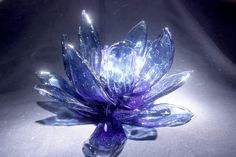 a purple glass flower sitting on top of a table