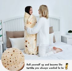 two women wrapped in blankets on top of a bed next to a tortilla