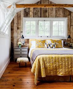 a bedroom with yellow bedding and white walls in the corner is featured in this magazine