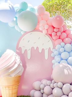 an ice cream sundae and balloons are on display in front of a backdrop for a birthday party