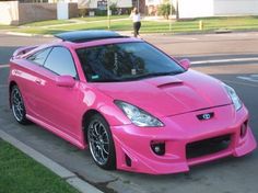 a pink sports car is parked on the street