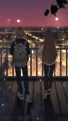 two people looking out over a city at night