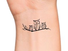 an owl family on a branch tattoo on the left side of the wrist is shown