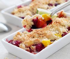 two white dishes filled with fruit and crumbled on top of eachother