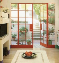 a living room filled with furniture and lots of glass doors leading to an outside patio