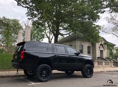 a black suv parked in front of a house