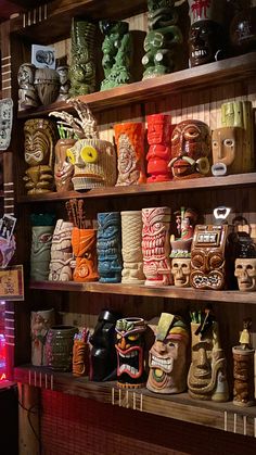 the shelves are filled with many different types of ceramic masks and vases on them