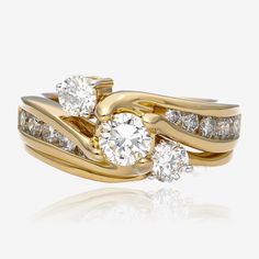 two gold wedding rings with diamonds on each one and an engagement ring in the middle