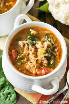 two white bowls filled with soup on top of a table