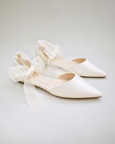 a pair of white shoes sitting on top of a white floor next to each other