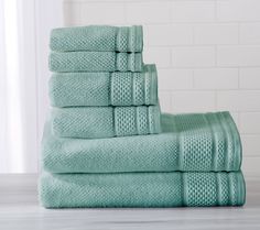 a stack of green towels sitting on top of a counter