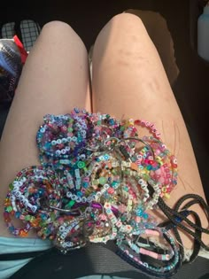 a woman's legs covered in lots of bracelets