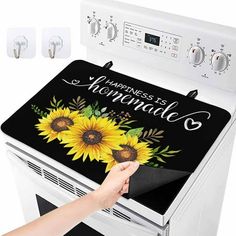 a woman is touching the top of an oven with sunflowers painted on it