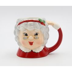 a ceramic santa clause mug with glasses and a red hat on it's head