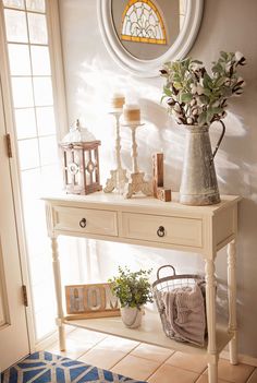 a white table with flowers and candles on it in front of a wall mounted mirror