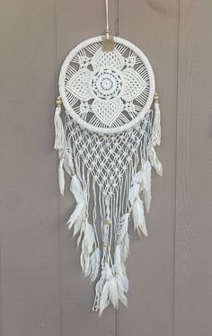 a white dream catcher hanging on the wall