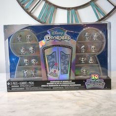 the back of a toy set in a box on a table with a clock behind it