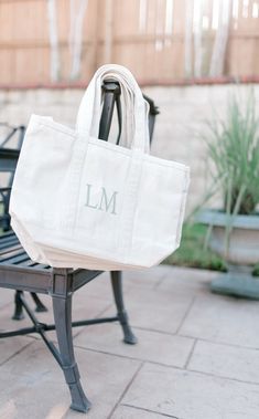 a white tote bag sitting on top of a bench