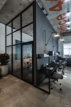 an office with glass walls and black desks