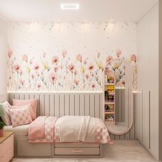 a bedroom decorated in pink and white with flowers on the wall, bedding and pillows