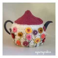 a crocheted tea pot with flowers on it