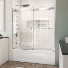 a bathroom with white tile and wooden floors