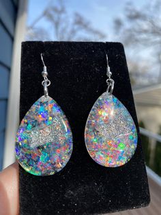 These Opal inspired Teardrop geode earrings made from resin colorshift to make a beautiful statement on your ears. They are lightweight and won't bother your ears. Handmade by Katie  KG Design & Decor Please follow my on social media  Instagram: @KG_DesignandDecor Facebook: KG Design and Decor Please be aware that this is handmade art and perfection has no place in art.  However, this was crafted with love and intention and I hope you are satisfied with your purchase. Your purchase is not refund Rainbow Sparkle, Geode Earrings, Design Decor, Christmas Magic, Resin Jewelry, Handmade Art, Druzy, Jewelry Earrings Dangle, Hippie Boho