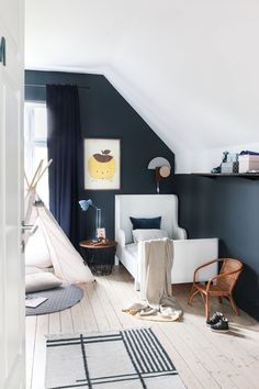 an attic bedroom with black walls and white furniture, including a hammock hanging from the ceiling