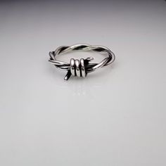 This is my original ring and my photos that I've taken. There are others selling this ring with my photos, I'm not responsible for the quality of their item  -Handmade barbed wire ring made from silver -Made from two 1,2mm silver wires, so the ring is approx. 2,4mm wide. -Every piece is made by me from sterling silver (Ag 925) -This ring is 100% handmade without any heavy machinery or automatization, so there might be slight differences from the pictures, but I always try to make it perfect. Edgy Silver Open Ring Jewelry, Edgy Silver Metal Rings, Edgy Adjustable Silver Rings, Edgy Metal Ring Gift, Silver Punk Rings For Streetwear, Edgy Silver Rings For Streetwear, Punk Style Sterling Silver Ring As Gift, Barbed Wire Ring, Blessing Ring