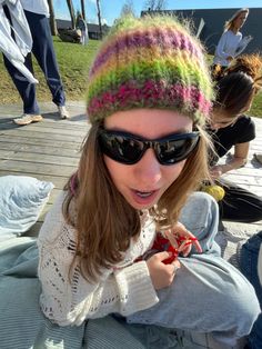 a woman wearing sunglasses and a knitted hat