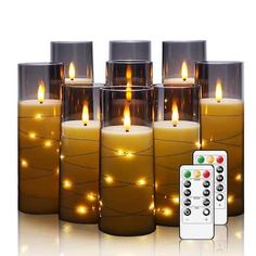 there are many lit candles with remotes next to them