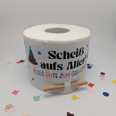 a roll of toilet paper sitting on top of a table next to confetti