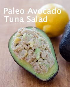 an avocado, lemon and tuna salad on a cutting board next to each other