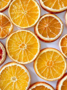 several oranges cut in half on a white surface