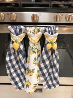 two lemons are hanging from the kitchen towel rack in front of an oven door