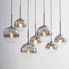 five clear glass globe lights hanging from a ceiling